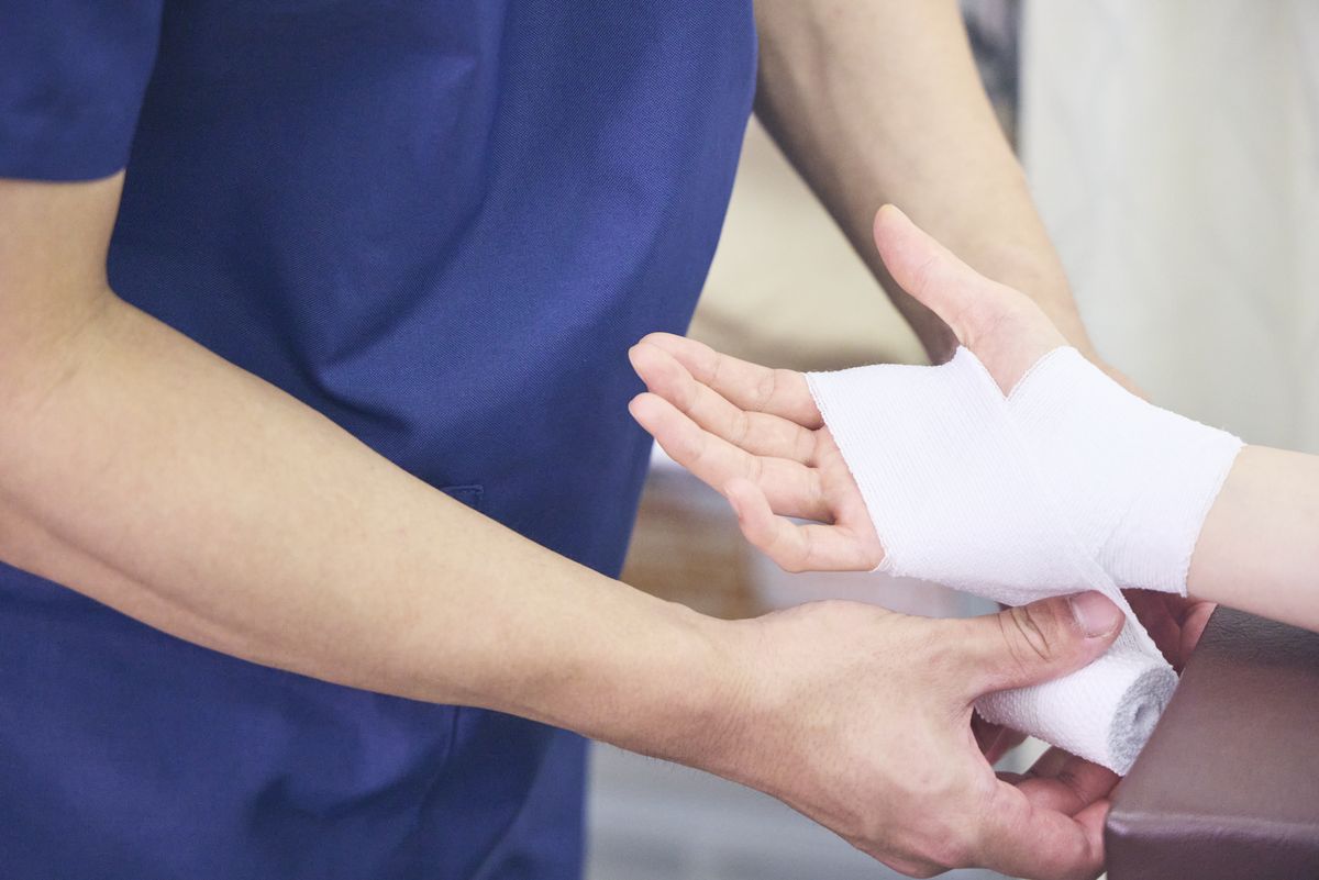 からだラボ整骨院グループのスタッフが、手首にテーピングをしている様子